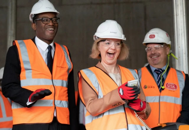 Liz Truss and Kwasi Kwarteng wearing high vis vests and hard hats