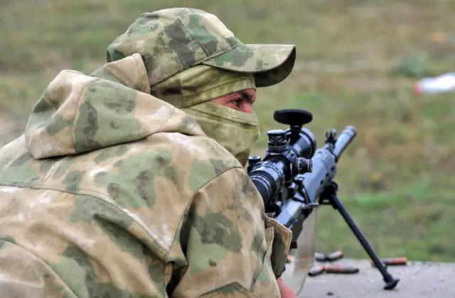 A Russian soldier crouches behind a gun during target practice in Rostov-on-Don