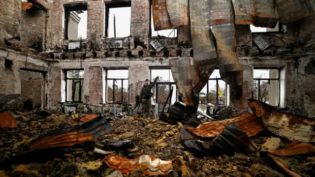 Illia Yerlash, a Ukranian army officer gestures as he stands among the remains of a school that was destroyed during the fighting between Russian troops and the Ukrainian army, amid Russia's invasion of Ukraine, in the recently liberated town of Lyman, Donetsk region, Ukraine, October 5 2022