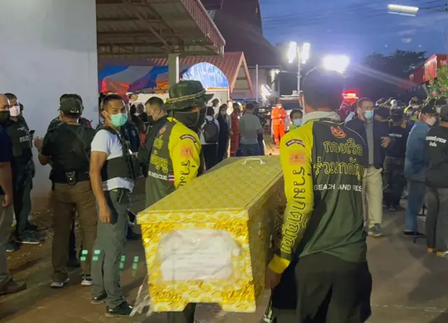 Rescue workers carry the coffin of one of the victims of the attack in Nong Bua Lamphu province