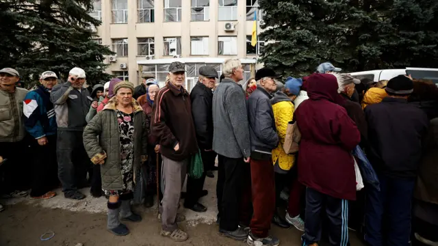 Local residents line up to receive humanitarian aid