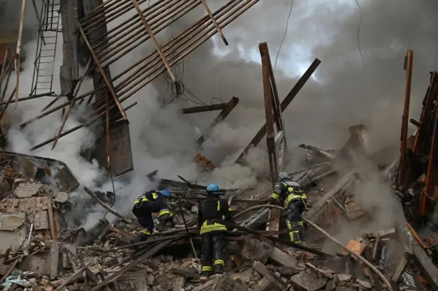 Rescue crews climb through the rubble of a destroyed building in Zaporizhzhia