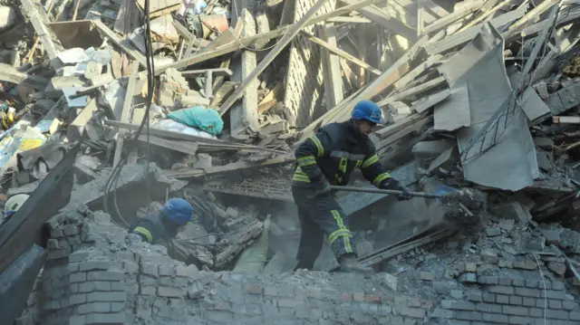 Rescuers search rubble in a heavily damaged residential building in Zaporizhzhia, Ukraine