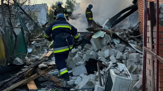 Emergency workers climb across rubble in Zaporizhzhia