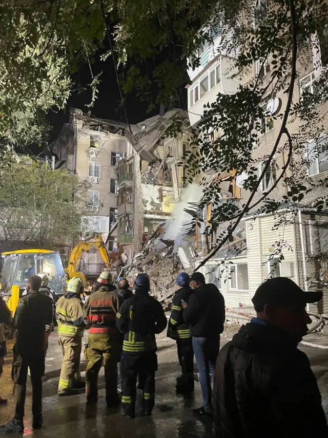 Emergency workers outside damaged apartment building in Zaporizhzhia