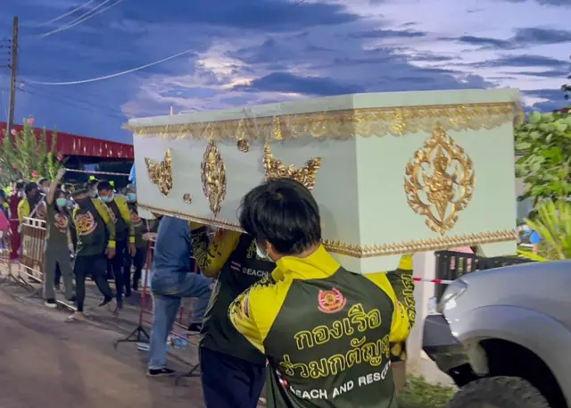 Rescue workers carry the coffin of one of the victims of the attack in Nong Bua Lamphu province