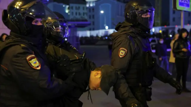 Russian police officers detain a person during an unsanctioned rally in Moscow