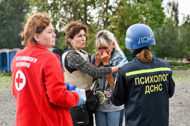 A woman is comforted by aid workers