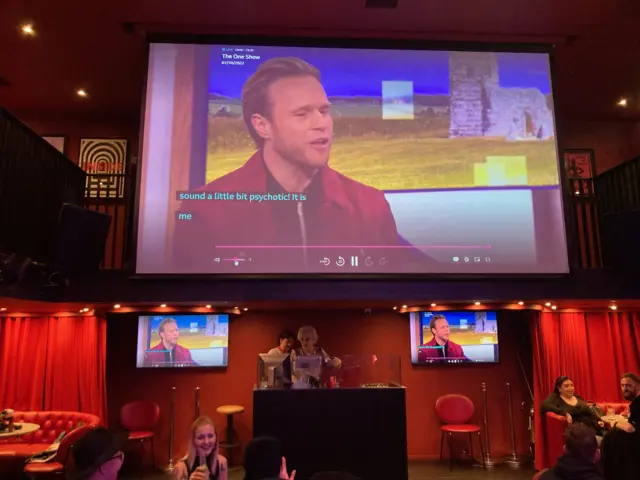 A photo of a big screen in a Glasgow bar screening the One Show