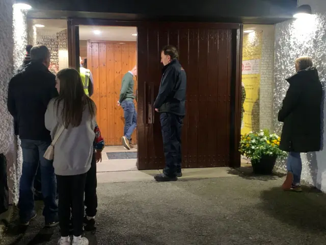 People stand in the doorway at St Michael's Church in Creeslough