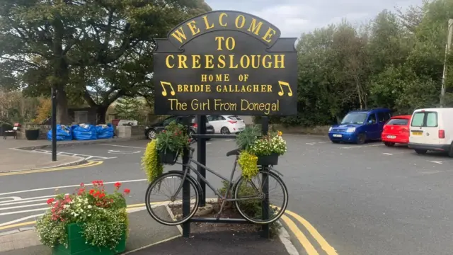 A sign that reads: Welcome to Creeslough - home of Bridie Gallagher, the girl from Donegal