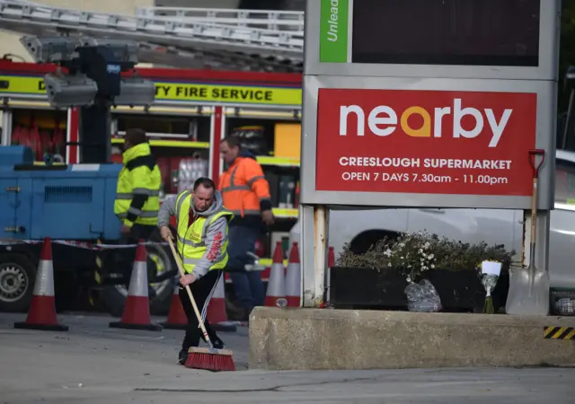 A man brushes rubble at the scene of the explosion in Creeslough