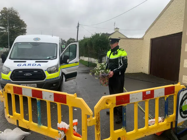 Police officer places flowers near the scene