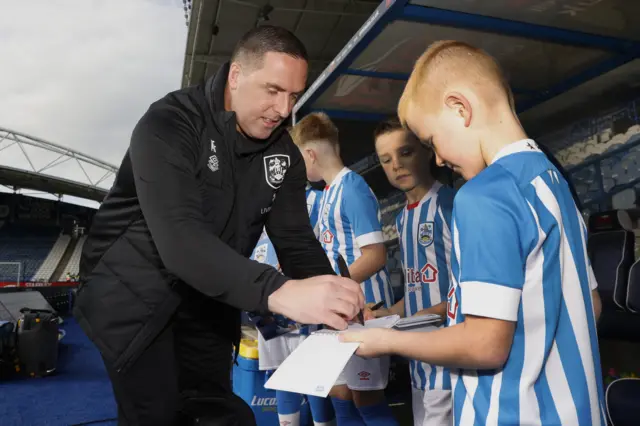 Huddersfield boss Mark Fotheringham signs autographs