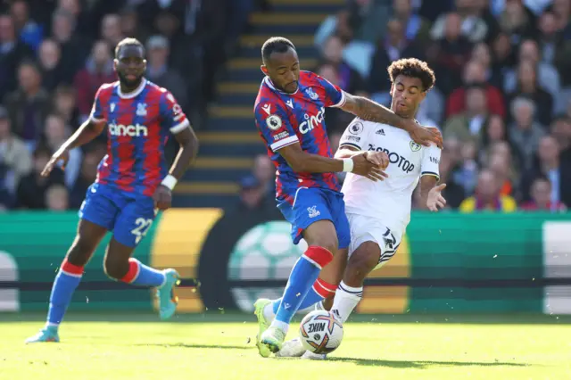 Jordan Ayew of Crystal Palace is challenged by Tyler Adams