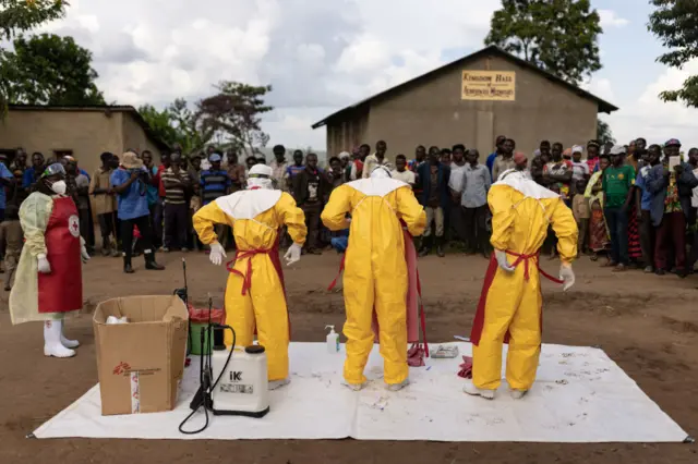 Red Cross workers in Uganda don PPE before burying a child who  died from Ebola