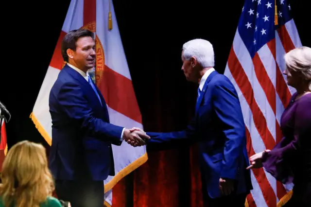 Republican Florida Governor Ron DeSantis (L) shakes hands with Democratic challenger Charlie Crist