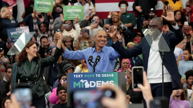 Former U.S. President Barack Obama raises his hands with Michigan Governor Gretchen Whitmer and Lieutenant Governor Garlin Gilchrist during a rally before mid-term elections in Detroit, Michigan, U.S. October 29, 2022