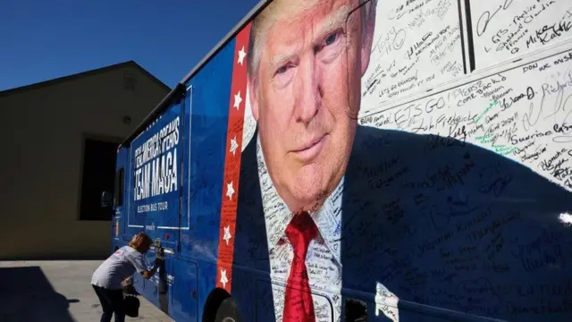 A campaign bus showing former President Donald Trump with signatures from supporters