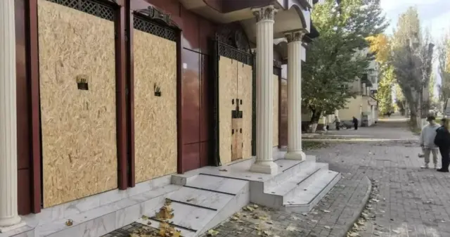 Boarded up shop windows in Kherson