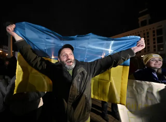 A man holds a Ukrainian flag aloft