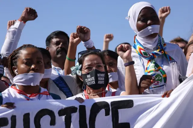 Activists wearing gags to symbolise the global shrinking of space for civil society attend a protest gathering to demand freedom for imprisoned human rights and environmental activists across the globe during the UNFCCC COP27 climate conference on November 10, 2022