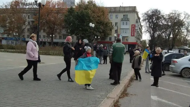 A young girl holding a Ukrainian flag in Kherson