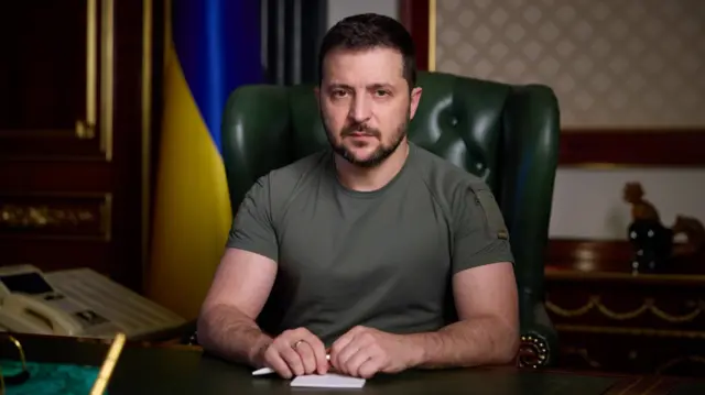 President Zelensky pictured sitting at a desk in address on his website