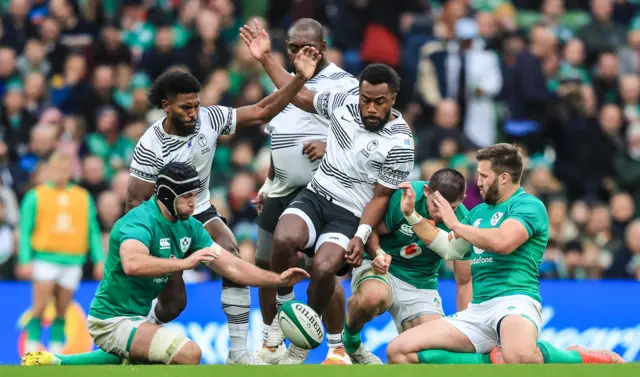 Players from both teams scramble for the ball