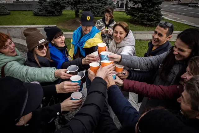 People raising paper cups