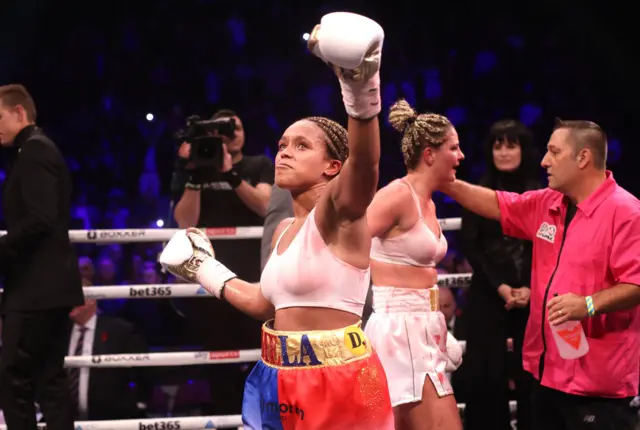 Natasha Jonas lifts her glove in victory