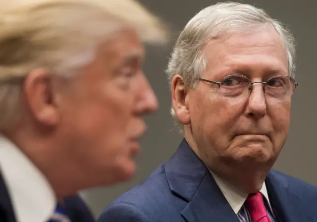 Mitch McConnell (right) looks on as Donald Trump speaks