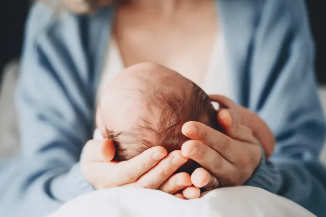 A mother holding her newborn baby