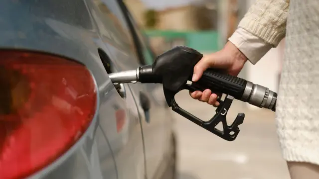 Person filling up a car with petrol