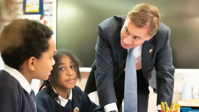 Jeremy Hunt met pupils at a primary school in south London after delivering his Autumn Statement to Parliament earlier today