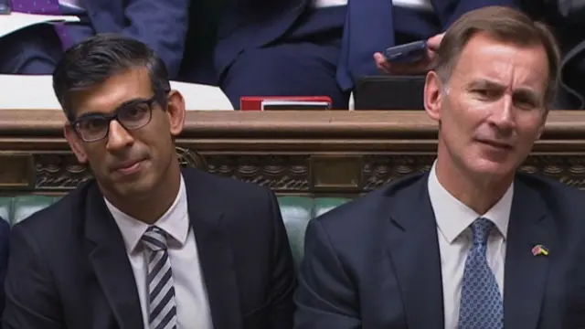 Rishi Sunak and Jeremy Hunt react as they listen to Reeves' response