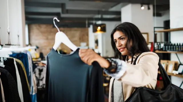 A woman looking at a top while shopping