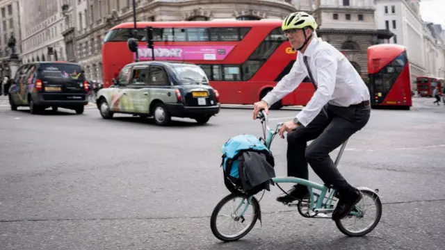 Businessman rides a Brompton bike through the City of London