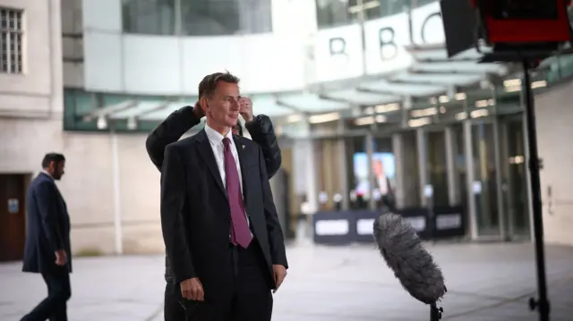 British Chancellor of the Exchequer Jeremy Hunt talks to a television crew outside the BBC headquarters in London