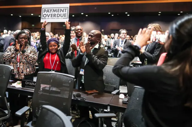 Nakeeyat Sam Dramani, a young poet from Ghana, holds a placard after giving a speech about global warming during the 2022 United Nations Climate Change Conference (COP27), in Sharm El-Sheikh, Egypt, 18 November 2022.