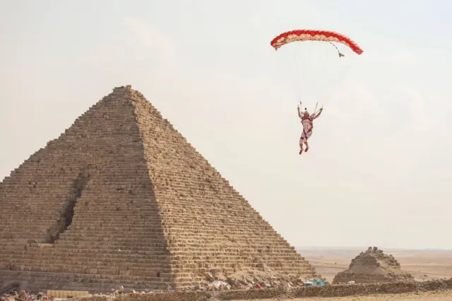 Skydivers fly over the pyramids of Giza during the skydiving festival with the participation of more than a thousand skydivers from 20 states on November 02, 2022, in Giza, Egypt