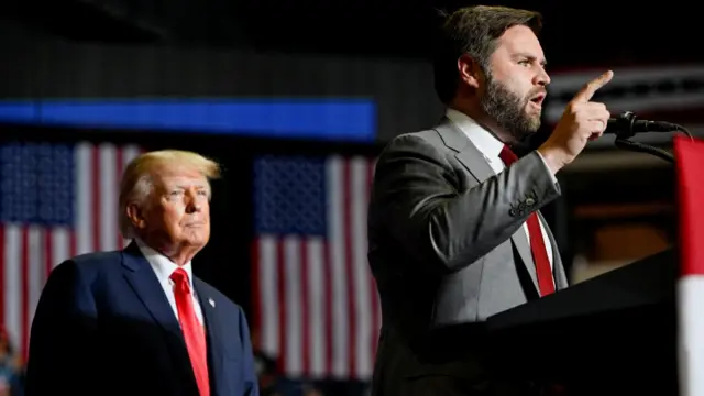 Former US president Donald Trump listens as JD Vance speaks during a rally in Youngstown, Ohio