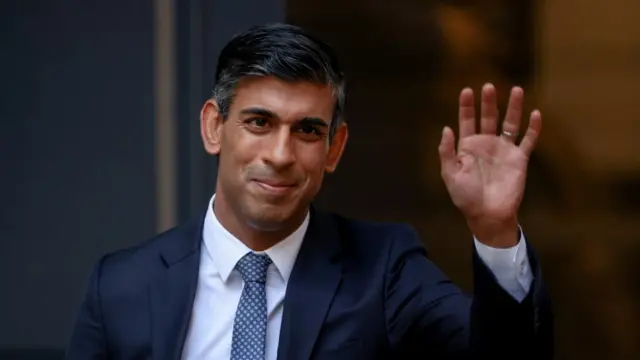 Rishi Sunak waves outside the party's headquarters in London