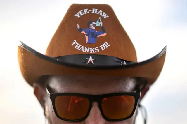 Mclaren team member wearing a cowboy hat reading 'yeehaw. thanks DR'