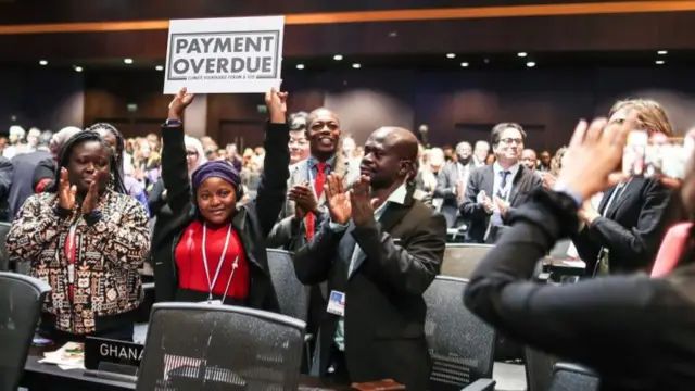 Nakeeyat Sam Dramani, a young poet from Ghana, holds a placard after giving a speech about global warming during the 2022 United Nations Climate Change Conference (COP27)