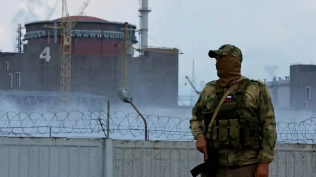 A serviceman with a Russian flag on his uniform stands guard near the Zaporzhzhia power plant, which is located in the city of Enerhodar, Zaporzhzhia Region, in south-eastern Ukraine.