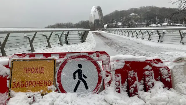 A blanket of snow and ice covers a bridge in Kyiv