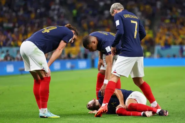 Lucas Hernandez is checked on by his team mates after going down injured