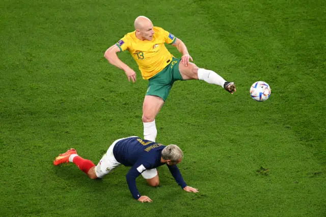 Aaron Mooy controls the ball with Antoine Griezmann on the floor