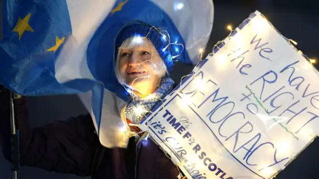 A person attends a rally outside the Scottish Parliament in Edinburgh